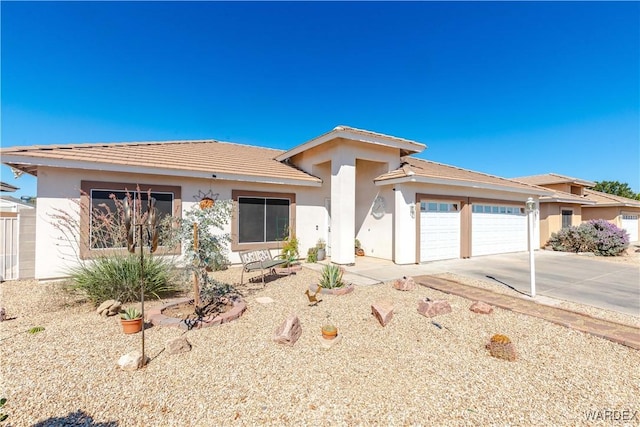 prairie-style house featuring concrete driveway, an attached garage, and stucco siding