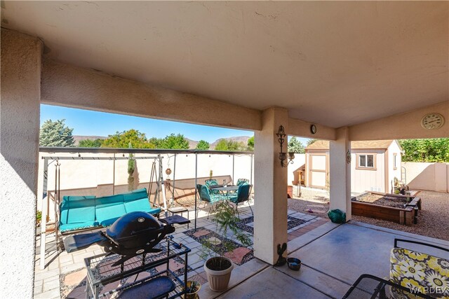 view of patio with a fenced backyard, outdoor dining area, area for grilling, and an outbuilding