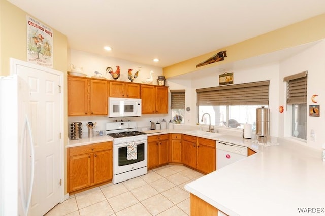 kitchen with brown cabinets, light countertops, light tile patterned flooring, a sink, and white appliances