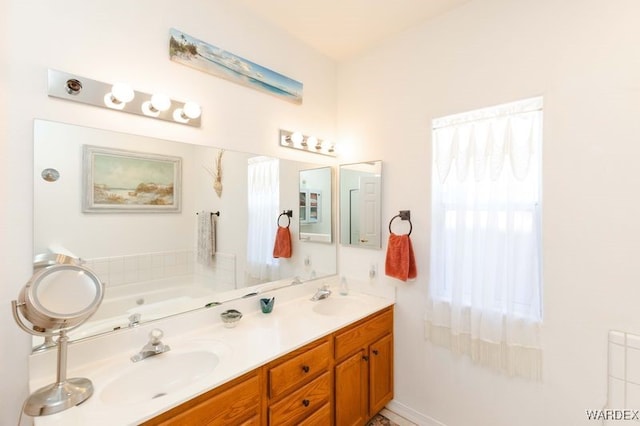 full bathroom with a garden tub, double vanity, and a sink