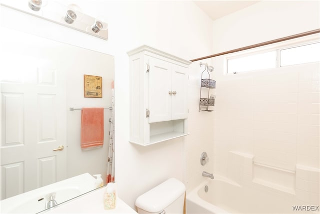 bathroom featuring shower / bath combination, toilet, and a sink