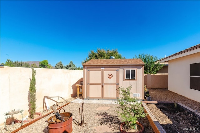 view of shed featuring a fenced backyard and a vegetable garden