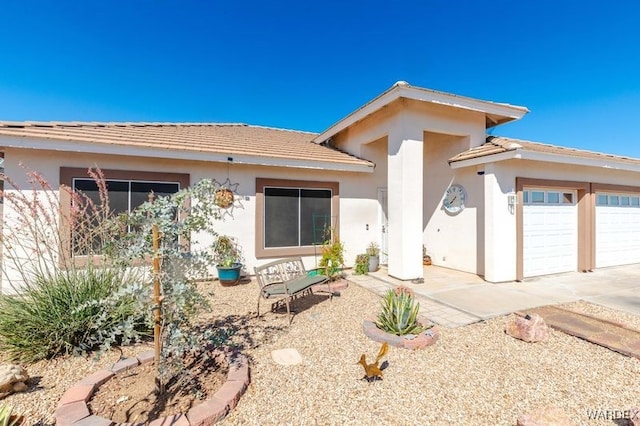 view of front facade with a garage and stucco siding