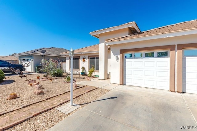 view of front facade featuring a garage, driveway, and stucco siding