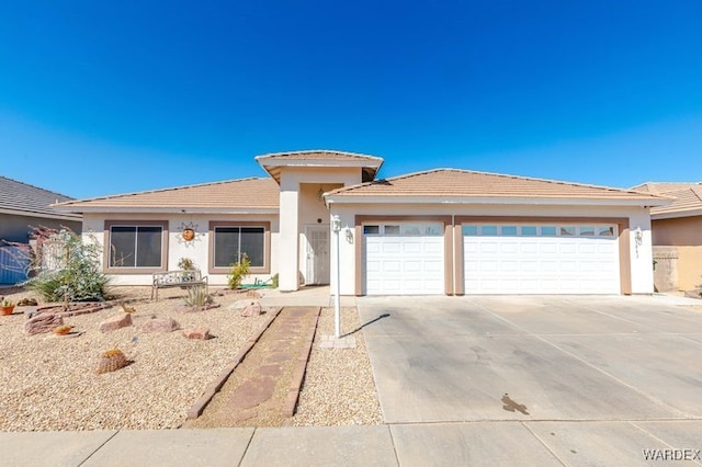 prairie-style home featuring a garage, a tile roof, driveway, and stucco siding