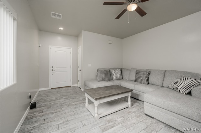 living room with light wood-type flooring, visible vents, a ceiling fan, recessed lighting, and baseboards