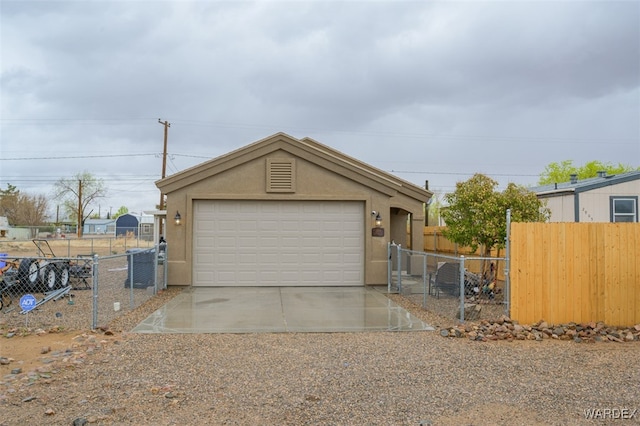 garage featuring driveway and fence