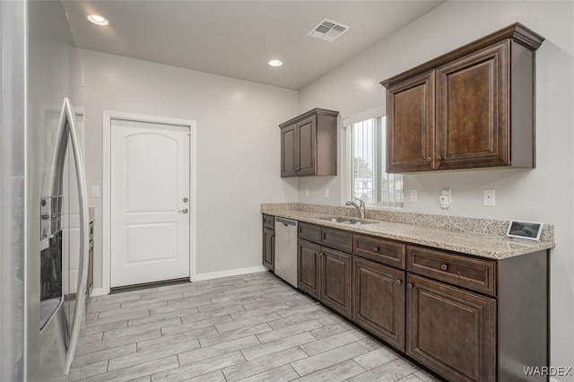 kitchen featuring a sink, dark brown cabinets, visible vents, and stainless steel appliances