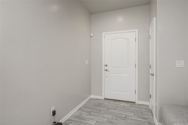 interior space with baseboards and wood tiled floor