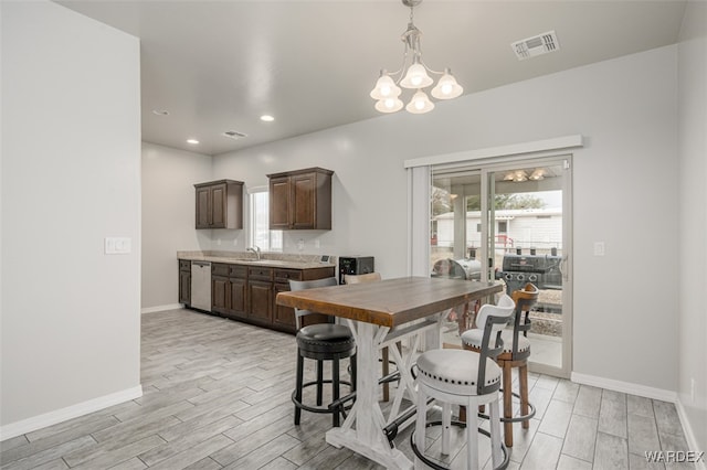 dining area featuring a notable chandelier, baseboards, visible vents, and wood tiled floor