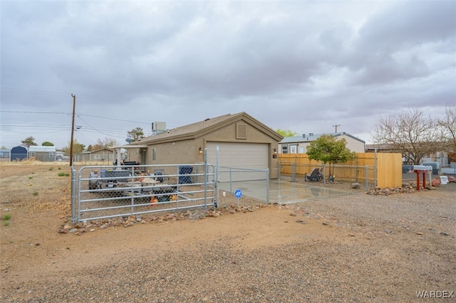 view of outdoor structure featuring driveway and fence