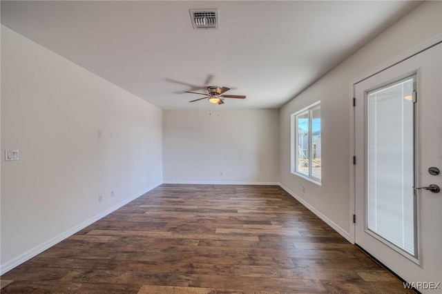 spare room featuring a ceiling fan, dark wood-type flooring, baseboards, and visible vents