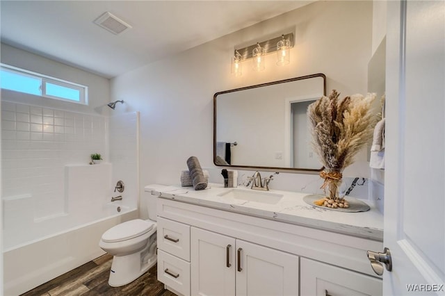 bathroom featuring visible vents, toilet, shower / bath combination, wood finished floors, and vanity