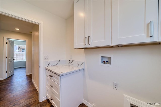 laundry room with hookup for a washing machine, cabinet space, dark wood-type flooring, and baseboards