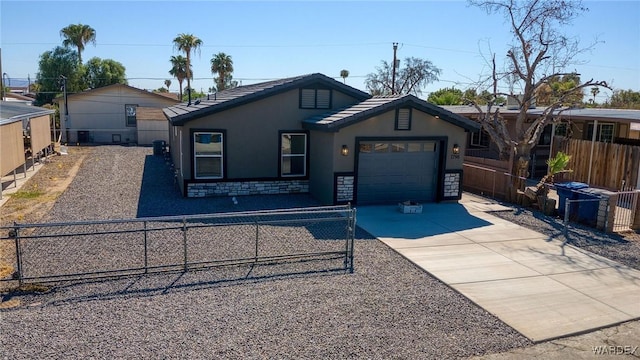 view of front of property with driveway, an attached garage, stucco siding, stone siding, and a fenced front yard