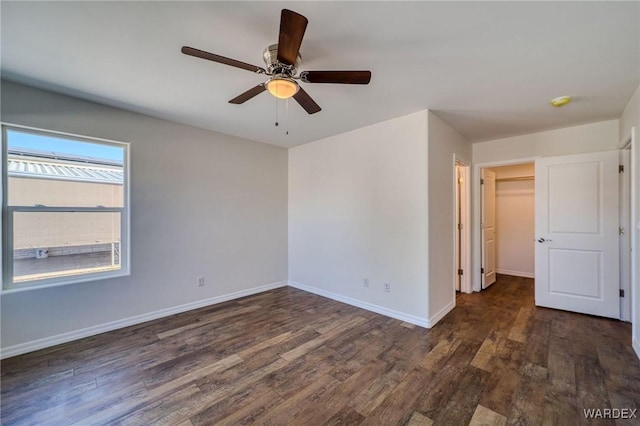 empty room featuring ceiling fan, baseboards, and wood finished floors