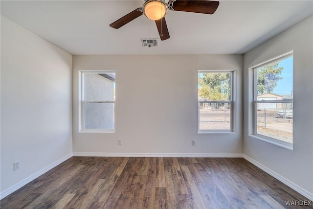 unfurnished room featuring visible vents, ceiling fan, baseboards, and wood finished floors