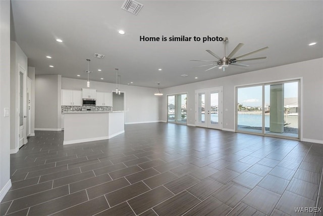 unfurnished living room with recessed lighting, visible vents, baseboards, and french doors