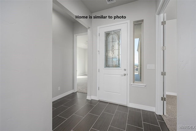 foyer entrance with visible vents and baseboards