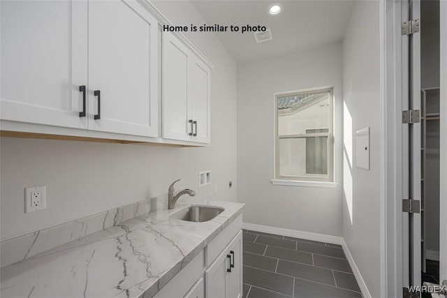 clothes washing area with recessed lighting, washer hookup, a sink, baseboards, and cabinet space