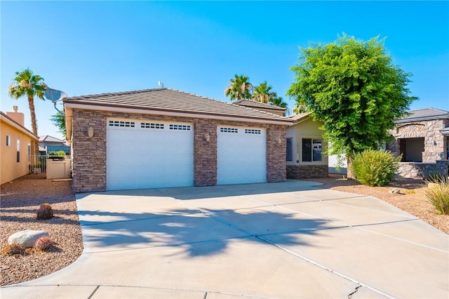 10726 S Shimmering Way, Mohave Valley, AZ 86440 - view of front of home with stone siding, a garage, a tile roof, and concrete driveway