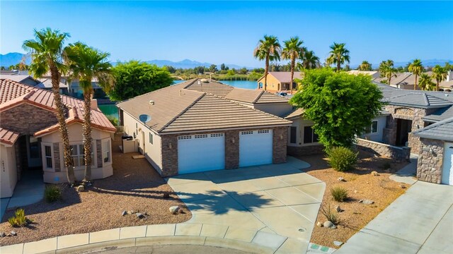 10726 S Shimmering Way, Mohave Valley, AZ 86440 - view of front of home with an attached garage, driveway, a tiled roof, a mountain view, and a residential view