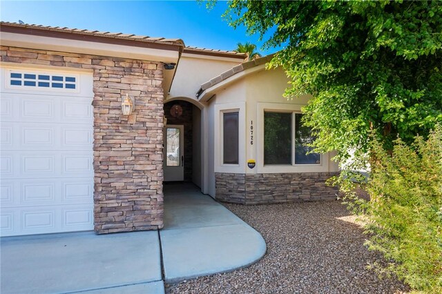 10726 S Shimmering Way, Mohave Valley, AZ 86440 - property entrance featuring stone siding, stucco siding, and a garage