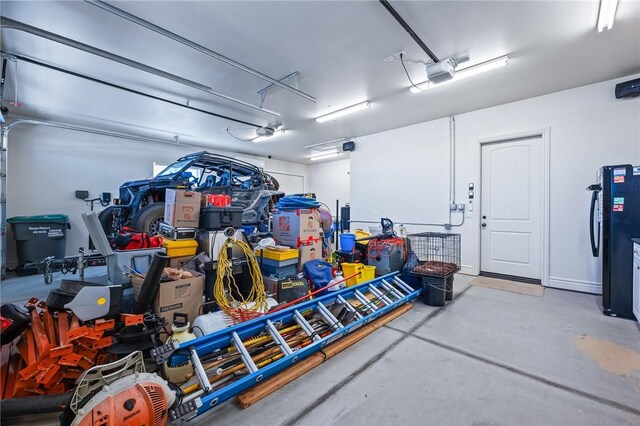 10726 S Shimmering Way, Mohave Valley, AZ 86440 - garage featuring a garage door opener and freestanding refrigerator