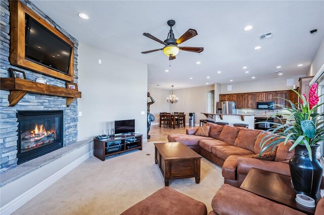 10726 S Shimmering Way, Mohave Valley, AZ 86440 - living room with light colored carpet, ceiling fan, recessed lighting, a stone fireplace, and a chandelier