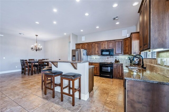 10726 S Shimmering Way, Mohave Valley, AZ 86440 - kitchen with black appliances, backsplash, a breakfast bar area, a kitchen island, and recessed lighting