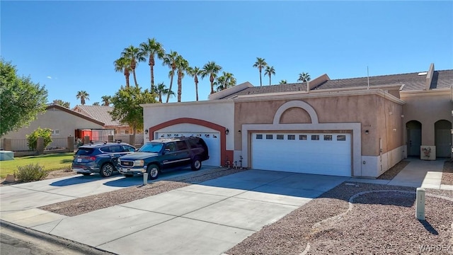 view of front facade with concrete driveway, an attached garage, and stucco siding