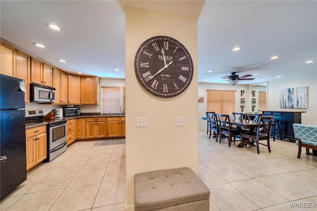 kitchen featuring light tile patterned floors, dark countertops, recessed lighting, appliances with stainless steel finishes, and brown cabinetry