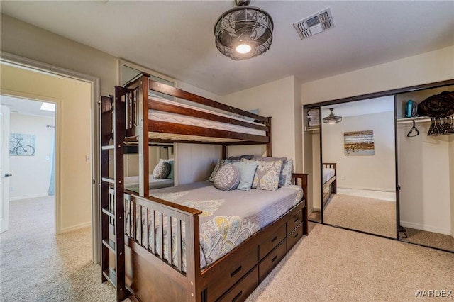 bedroom with baseboards, visible vents, and light colored carpet