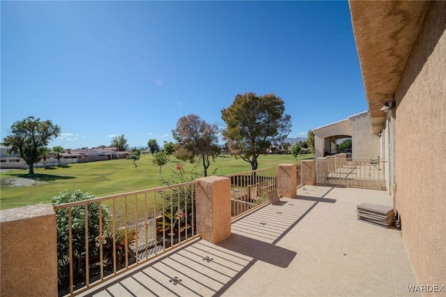 view of patio with golf course view and a balcony