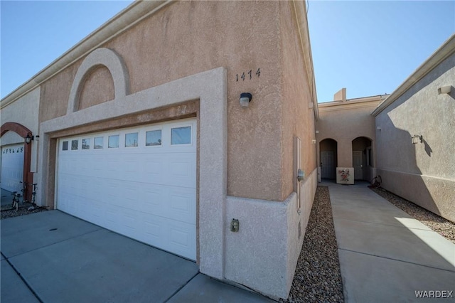 exterior space with a garage and stucco siding