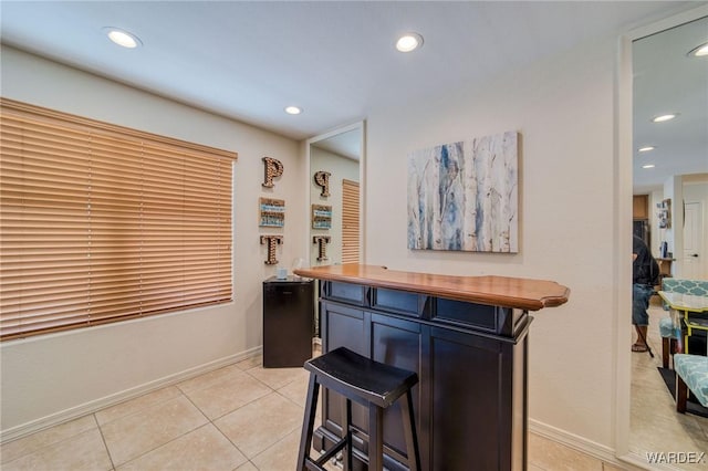 bar with light tile patterned floors, baseboards, and recessed lighting