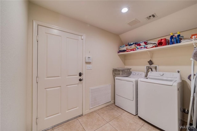 laundry area featuring laundry area, visible vents, washer and clothes dryer, and light tile patterned flooring