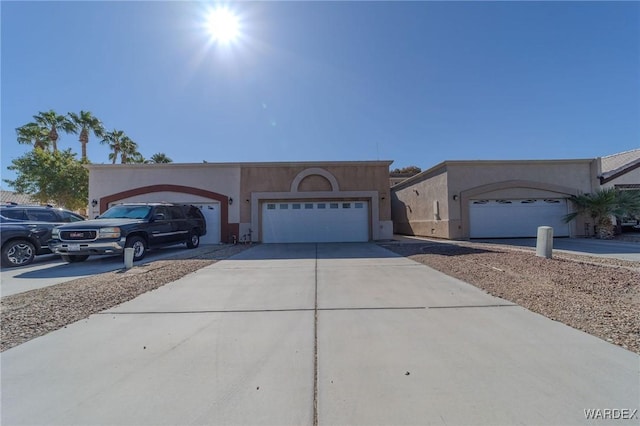 view of front of house featuring a garage, concrete driveway, and stucco siding