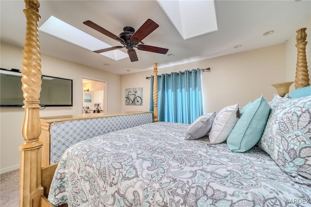 carpeted bedroom with a skylight and a ceiling fan