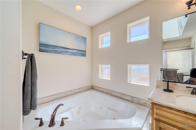 full bathroom featuring a stall shower, plenty of natural light, vanity, and a whirlpool tub