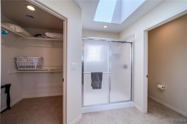 full bathroom featuring recessed lighting, a skylight, visible vents, a shower stall, and a walk in closet