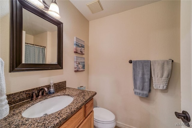 full bath with toilet, baseboards, visible vents, and vanity