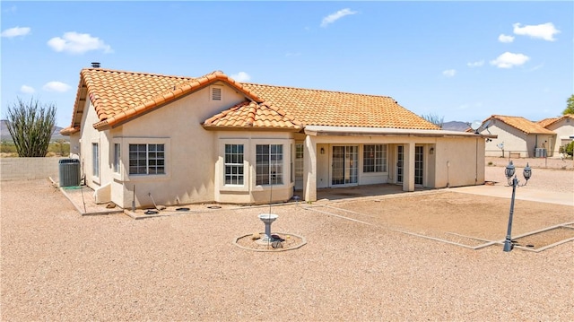 3628 N Venus Ct, Golden Valley, AZ 86413 - rear view of property featuring a tiled roof, central AC unit, stucco siding, and a patio