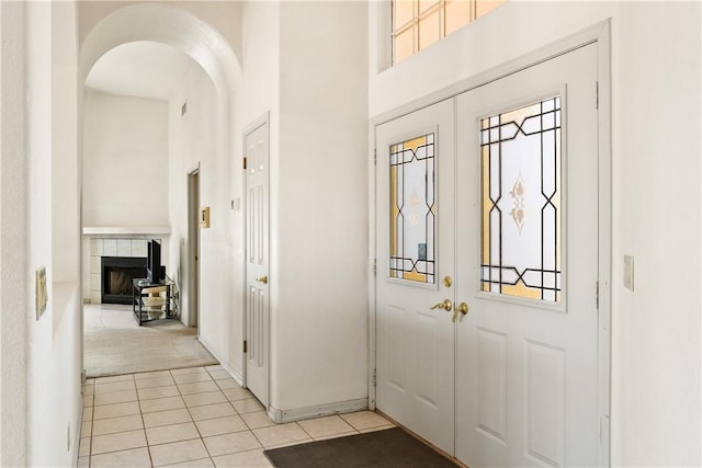3628 N Venus Ct, Golden Valley, AZ 86413 - foyer featuring a tile fireplace, arched walkways, light tile patterned floors, french doors, and a towering ceiling