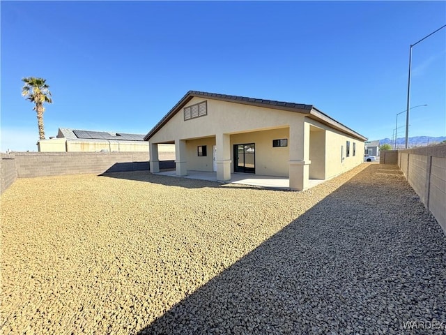 back of property with a patio, a fenced backyard, and stucco siding