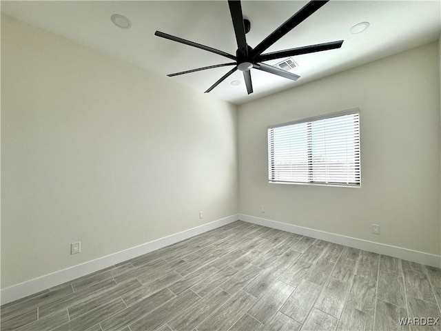 spare room featuring light wood-type flooring, baseboards, visible vents, and a ceiling fan