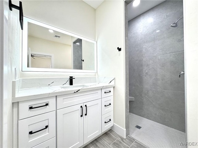 full bathroom with a ceiling fan, visible vents, vanity, and a shower stall