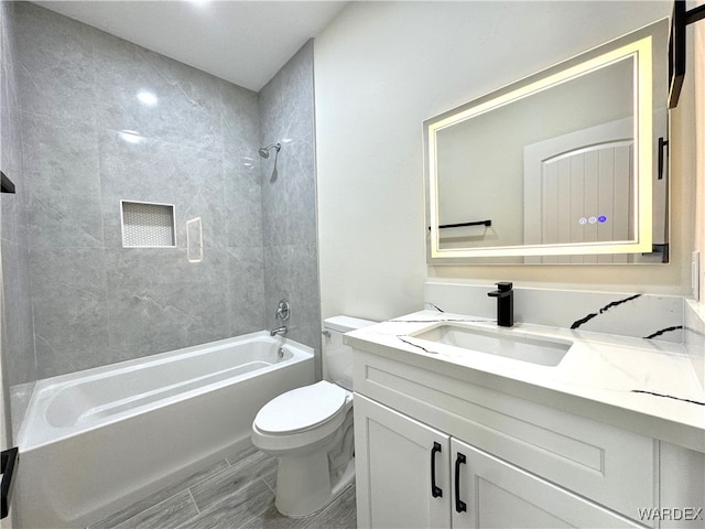 bathroom featuring toilet, shower / tub combination, and vanity