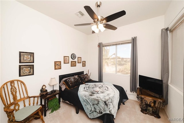 bedroom with ceiling fan, visible vents, and light colored carpet