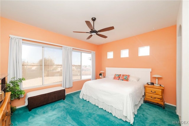 bedroom with a ceiling fan, dark colored carpet, and baseboards